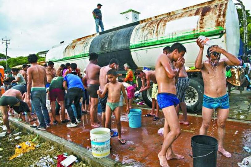 難民連洗澡也在車軌上解決。美聯社 難民連洗澡也在車軌上解決。美聯社