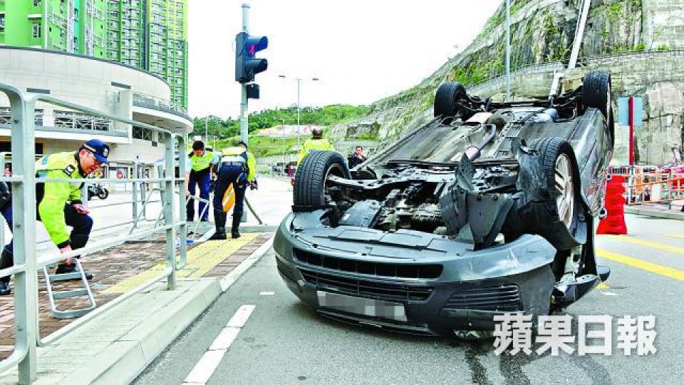 私家車撞毀鐵欄後四輪朝天。 私家車撞毀鐵欄後四輪朝天。