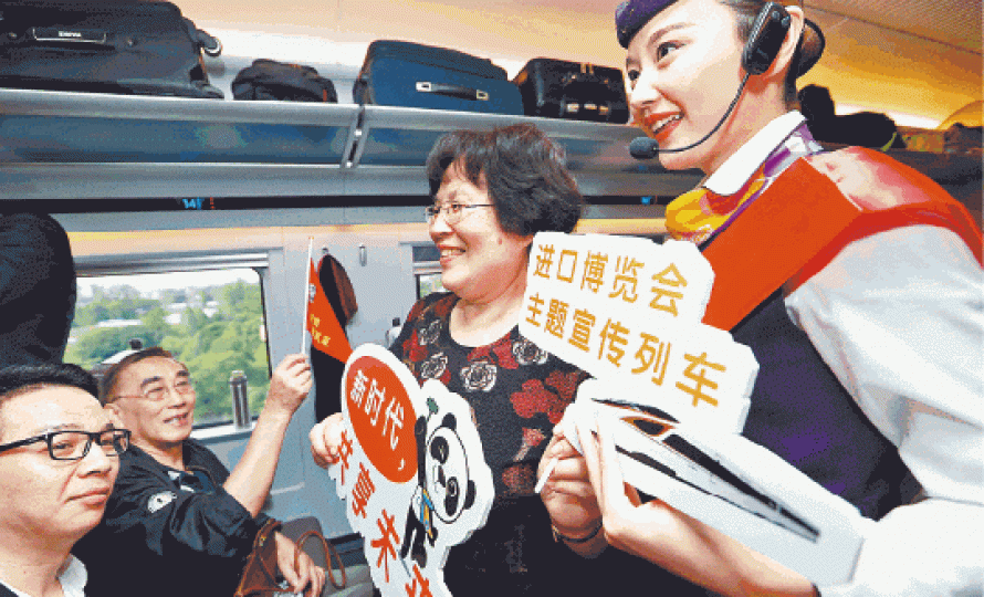乘務員在火車上向乘客宣傳進博會。 乘務員在火車上向乘客宣傳進博會。