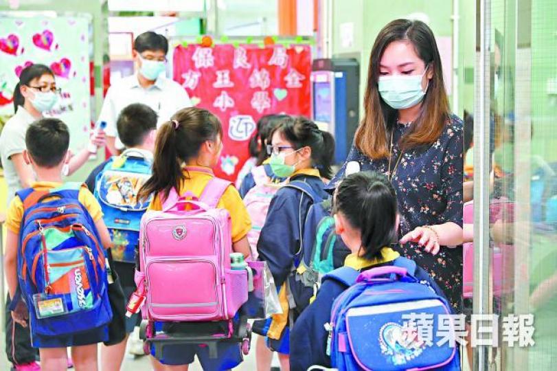 方王錦全小學教職員昨為返校的學童量度體溫。何家達攝學童使用酒精搓手液消毒雙手。 方王錦全小學教職員昨為返校的學童量度體溫。何家達攝學童使用酒精搓手液消毒雙手。