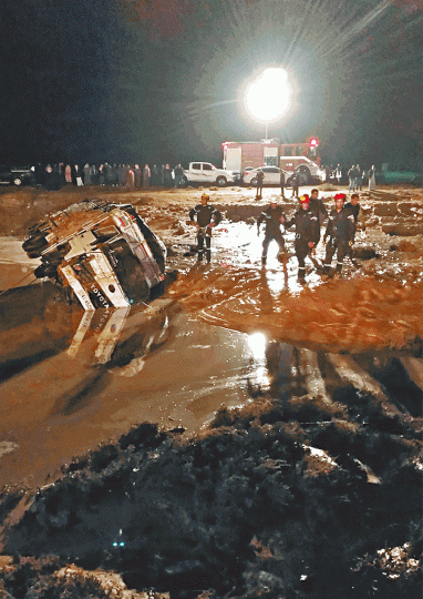 洪水沖毀道路,汽車半埋在泥濘中。 洪水沖毀道路,汽車半埋在泥濘中。