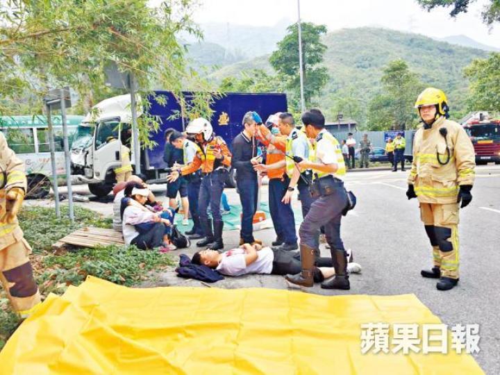 救援人員在現場為車禍傷者包紮。肇事專線小巴及貨車車頭嚴重損毀。 救援人員在現場為車禍傷者包紮。肇事專線小巴及貨車車頭嚴重損毀。