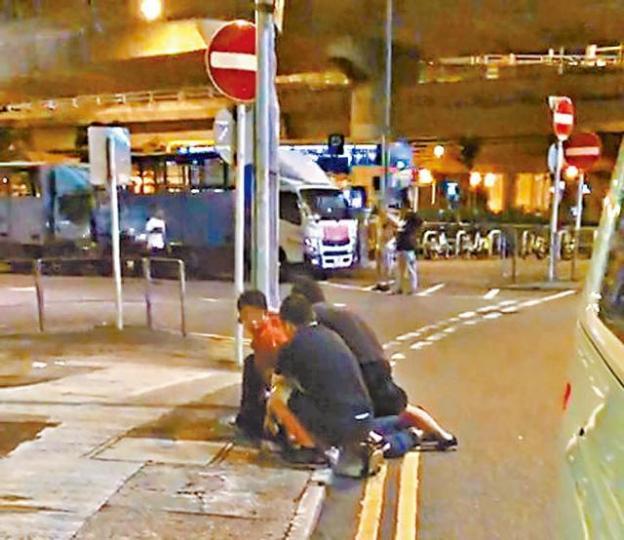 三名車房職員把一名男子按地毆打。警員在車房調查。溫文學攝 三名車房職員把一名男子按地毆打。警員在車房調查。溫文學攝