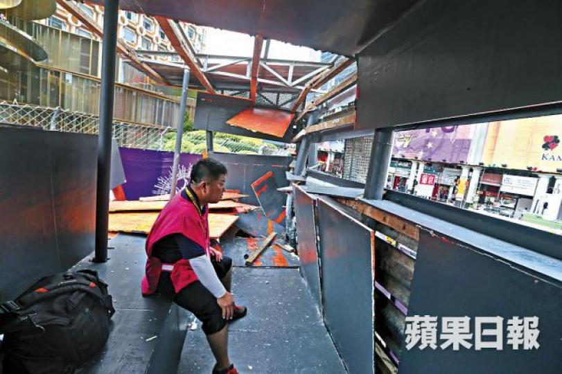 攝影台被撞散後,一名記者驚魂未定坐在一旁休息。 攝影台被撞散後,一名記者驚魂未定坐在一旁休息。