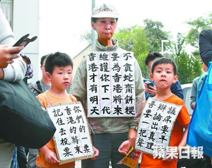 梁伯與孫兒身上掛着自製宣傳牌為李卓人拉票。謝榮耀攝 梁伯與孫兒身上掛着自製宣傳牌為李卓人拉票。謝榮耀攝