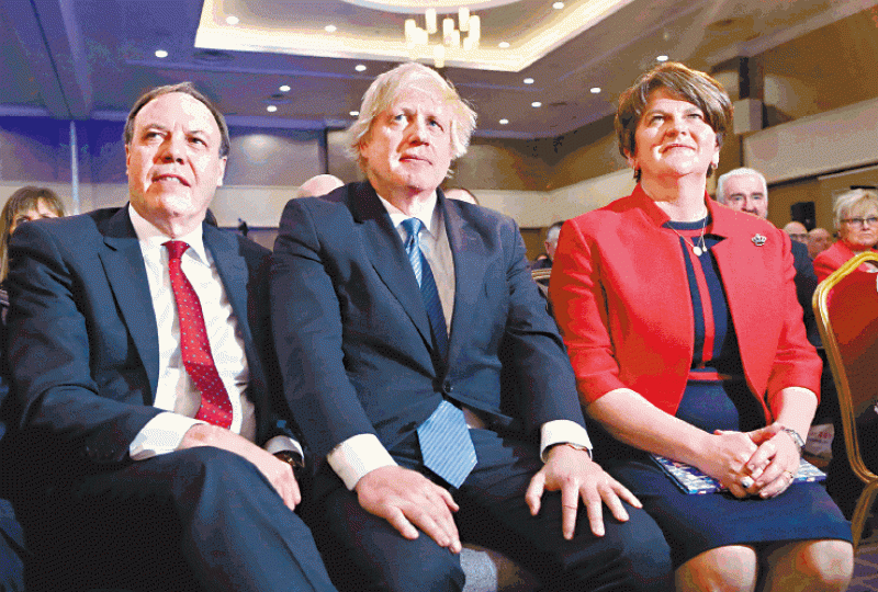 英國前外相約翰遜(中)出席民主統一黨黨大會,跟該黨黨魁范愛玲(右)和副黨魁多德(左)並排而坐。法新社 英國前外相約翰遜(中)出席民主統一黨黨大會,跟該黨黨魁范愛玲(右)和副黨魁多德(左)並排而坐。法新社