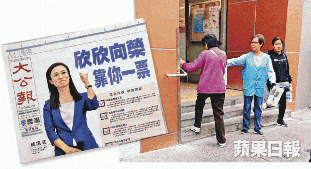 派報員於九龍城街市禁止拉票區向市民派發免費《大公報》精華版;左圖為前日出版的《大公報》。 派報員於九龍城街市禁止拉票區向市民派發免費《大公報》精華版;左圖為前日出版的《大公報》。