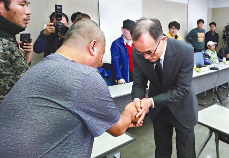 文武日跟受害人握手致歉。 文武日跟受害人握手致歉。