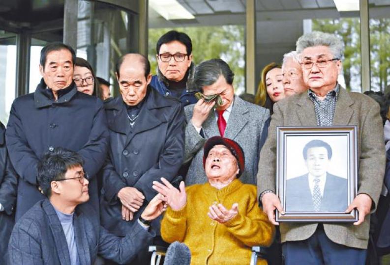 一名勝訴前工人(中)在法院外憶述當年苦況。美聯社 一名勝訴前工人(中)在法院外憶述當年苦況。美聯社