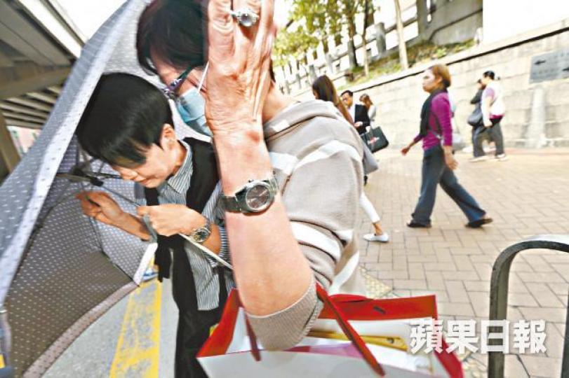 申索的國泰退休空姐離庭時以雨傘和口罩遮面。王子俊攝 申索的國泰退休空姐離庭時以雨傘和口罩遮面。王子俊攝