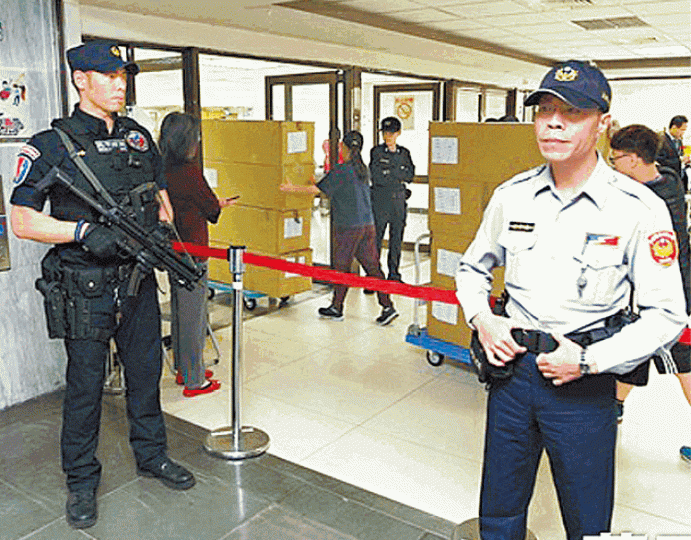 警員荷槍實彈在驗票現場戒備。台灣《蘋果日報》 警員荷槍實彈在驗票現場戒備。台灣《蘋果日報》