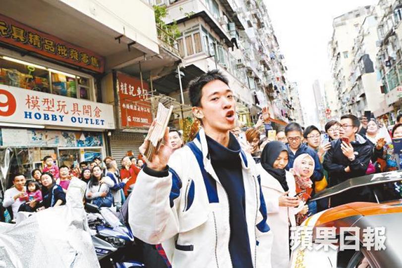 幣少爺昨午手持一大叠紙幣重返黃金商場外,大批途人包圍起哄。梁瑞帆攝 幣少爺昨午手持一大叠紙幣重返黃金商場外,大批途人包圍起哄。梁瑞帆攝