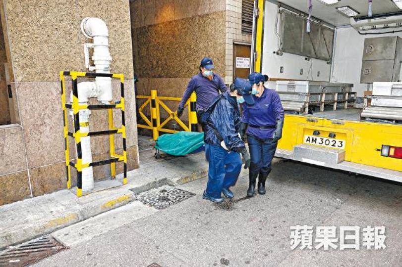 仵工移走男死者遺體。胡恩宏攝 仵工移走男死者遺體。胡恩宏攝