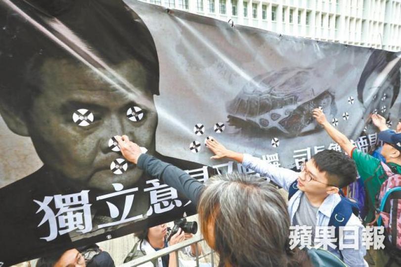 遊行人士在梁振英海報貼交叉以示不滿。 遊行人士在梁振英海報貼交叉以示不滿。