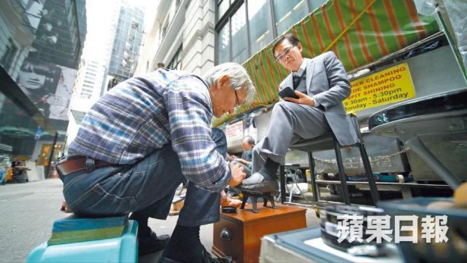走過上世紀70年代中環風光歲月,如今明哥低頭彎腰,為步伐匆匆的中環人,擦亮鞋履。明哥小休時愛聽英文歌。70年代仍未電子化,交易所現場電話此起彼落,紅衫仔四出奔跑畫板。 走過上世紀70年代中環風光歲月,如今明哥低頭彎腰,為步伐匆匆的中環人,擦亮鞋履。明哥小休時愛聽英文歌。70年代仍未電子化,交易所現場電話此起彼落,紅衫仔四出奔跑畫板。