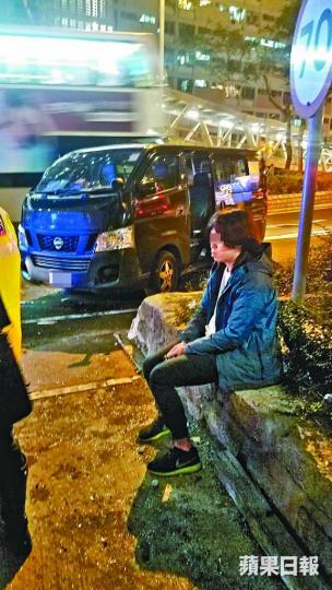 涉事客貨車司機被救出後呆坐一旁。 涉事客貨車司機被救出後呆坐一旁。