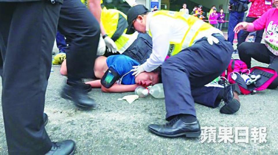 28歲男跑手於八公里賽事終點前不足200米倒地昏迷,救護員為他急救。周智堅攝 28歲男跑手於八公里賽事終點前不足200米倒地昏迷,救護員為他急救。周智堅攝