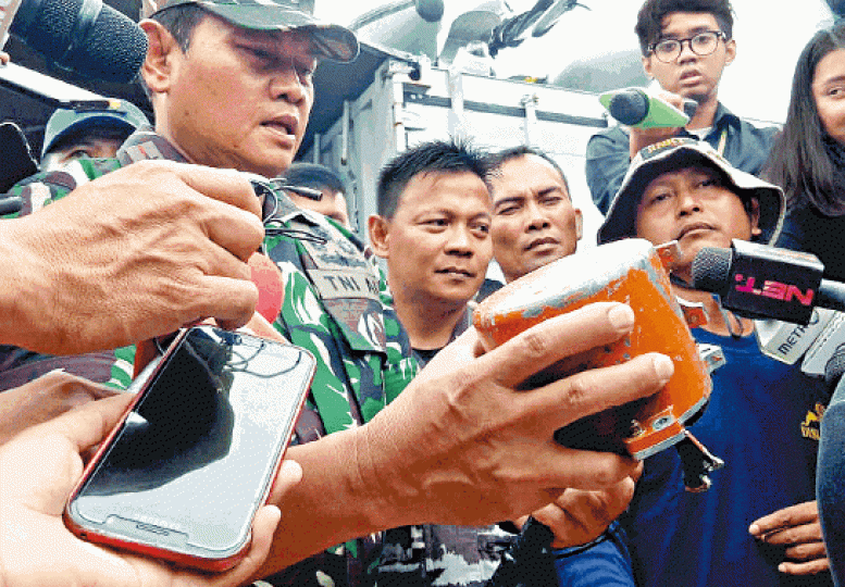 印尼海軍軍官向記者展示獅航失事客機黑盒的機艙錄音器。美聯社 印尼海軍軍官向記者展示獅航失事客機黑盒的機艙錄音器。美聯社