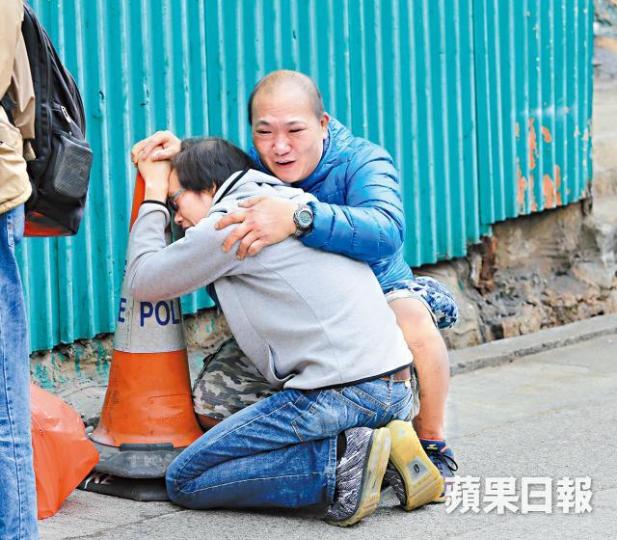死者父親路祭期間跪地嚎哭,親友在旁安慰。梁瑞帆攝 死者父親路祭期間跪地嚎哭,親友在旁安慰。梁瑞帆攝