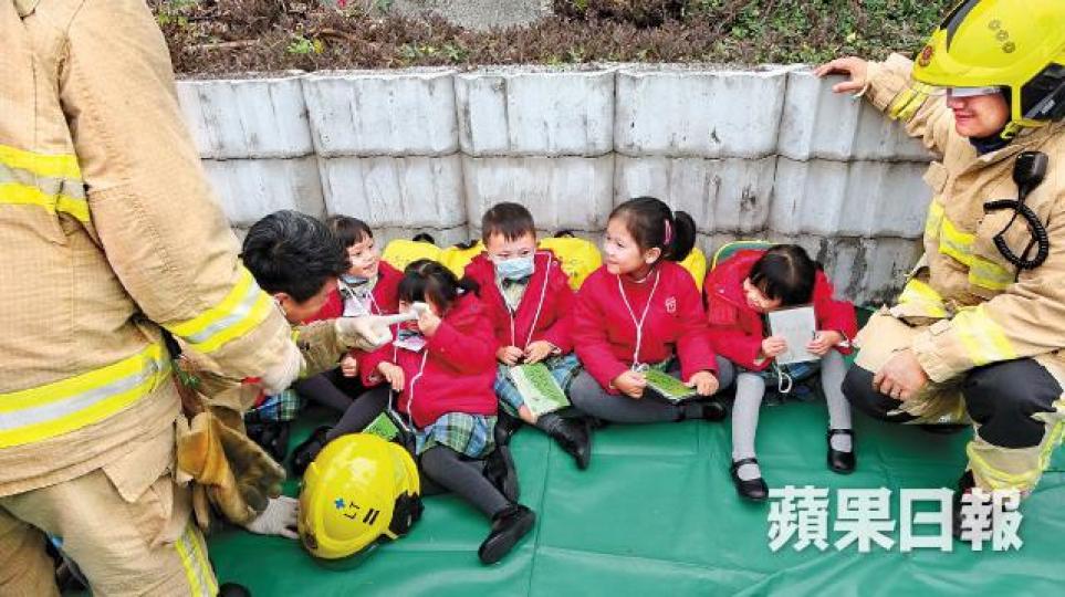 消防員安慰受驚學童,令他們破涕為笑。劉永明攝疑收掣不及的校巴司機在場協助調查。 消防員安慰受驚學童,令他們破涕為笑。劉永明攝疑收掣不及的校巴司機在場協助調查。