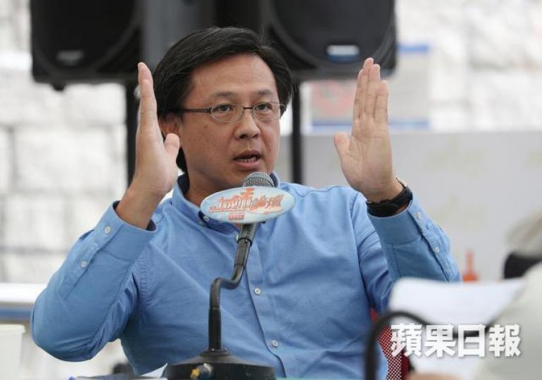 何君堯身穿建制藍恤衫，加一副細size幼框眼鏡，完美示範建制派穿搭的重點。　資料圖片