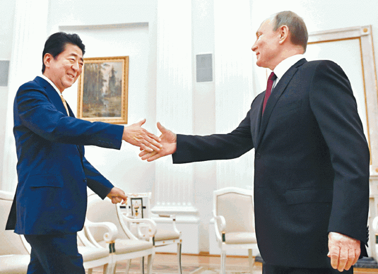 安倍晉三(左)與普京在會談正式開始前面帶笑容握手。 安倍晉三(左)與普京在會談正式開始前面帶笑容握手。