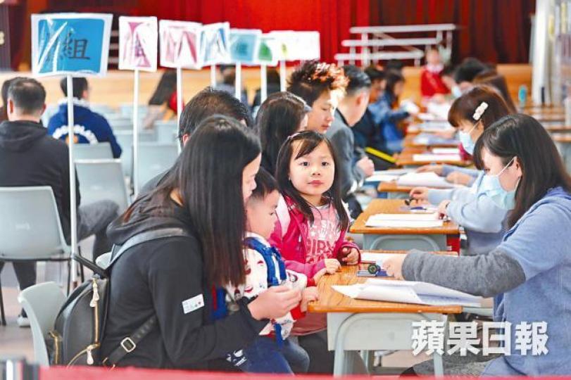 家長為子女遞交小一入學申請表格。黃耀興攝派位中心外排長龍,小孩坐在篋上歇息。 家長為子女遞交小一入學申請表格。黃耀興攝派位中心外排長龍,小孩坐在篋上歇息。