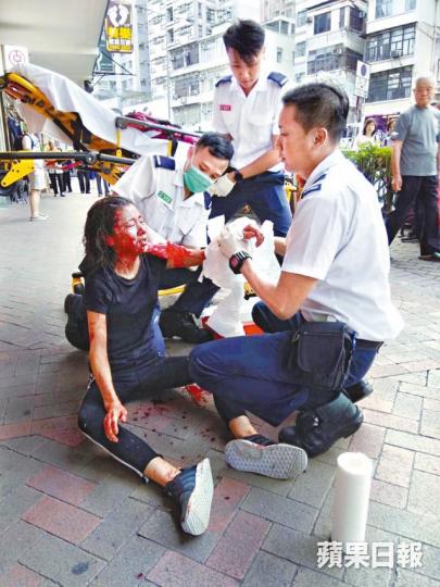 女事主當日遇襲後血流披面跑到街上求助,救護員到場替她急救。 女事主當日遇襲後血流披面跑到街上求助,救護員到場替她急救。