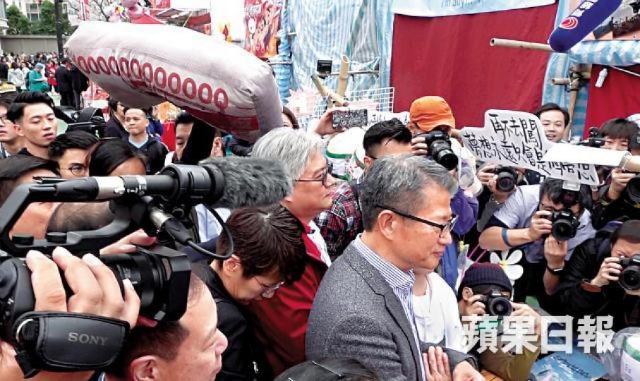 財政司長陳茂波昨到維園時，被高舉「一萬億元咕(o臣)」的社民連成員狙擊。何頴賢攝陳茂波事後獨自到天后港鐵站用八達通入閘乘車離開。