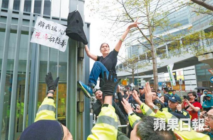 「女長毛」爬上政府總部大閘逃避保安員及警方追逐。張志華攝 「女長毛」爬上政府總部大閘逃避保安員及警方追逐。張志華攝