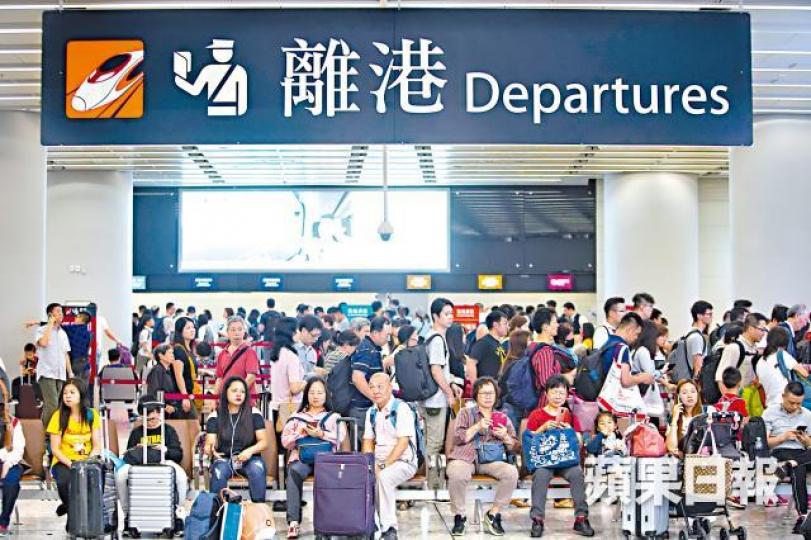 旅客昨於離港大堂等候入閘,大打蛇餅。西九站有不少旅行團集合,令人潮更擁擠。王心義攝 旅客昨於離港大堂等候入閘,大打蛇餅。西九站有不少旅行團集合,令人潮更擁擠。王心義攝