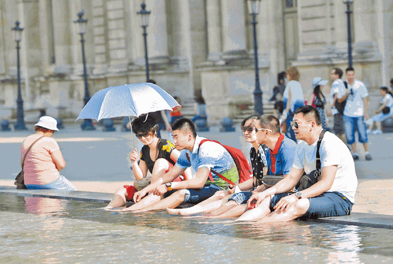 法國是中國人旅遊熱門地；圖為中國客在羅浮宮外洗腳。　資料圖片