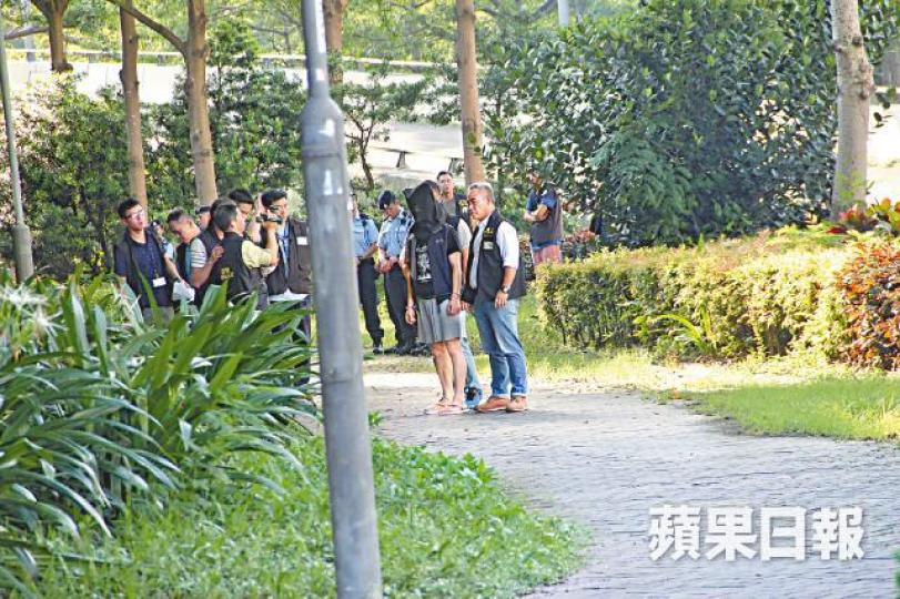 被告甘俊傑落網後,警員將他蒙頭帶返現場重組案情。資料圖片 被告甘俊傑落網後,警員將他蒙頭帶返現場重組案情。資料圖片