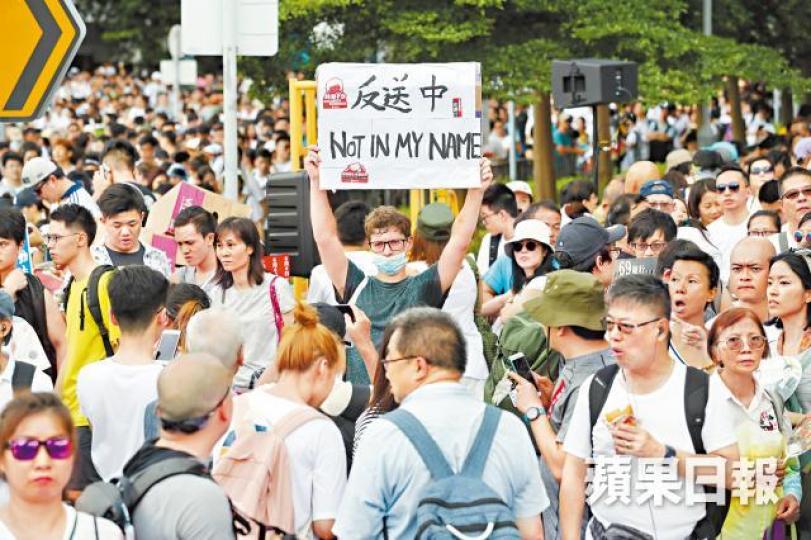 一個標語、一把黃傘，足以表達本地異鄉人對修例的憤慨。易仰民攝
